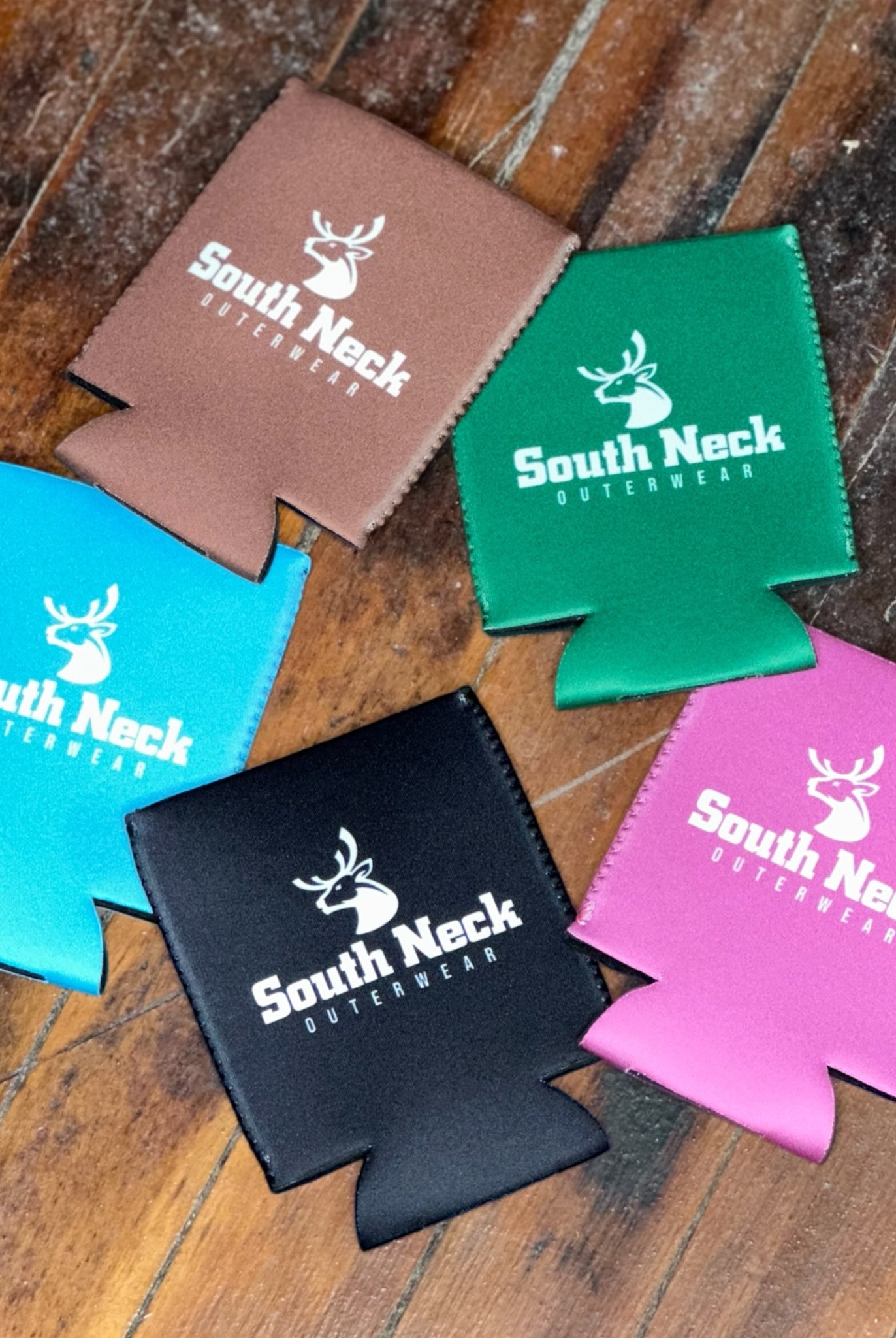 Five colorful South Neck Outerwear neoprene koozies – black, brown, green, blue, and pink drink holders with logo